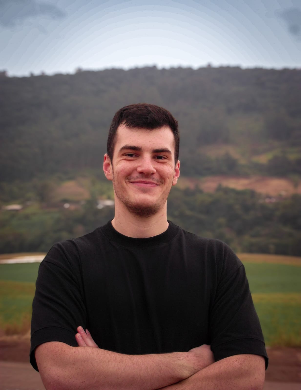 Henrique Konrad sorrindo em frente a uma paisagem
